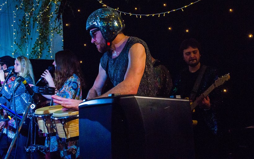 Man in helmet plays bongos at Ash Barton Devon