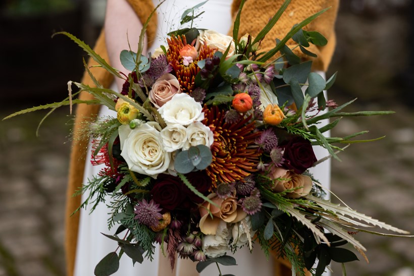 Winter wedding bouquet with roses and thistles