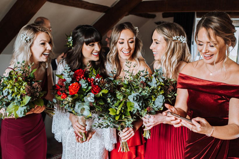 Bridesmaids wearing red and bride celebrate a winter wedding at Ash Barton