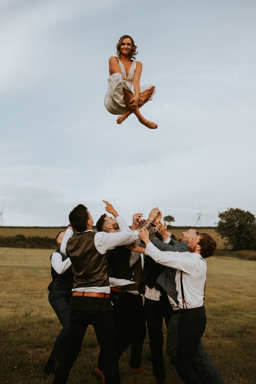 Bride gets thrown in the air cross legged at Ash Barton wedding venue Devon