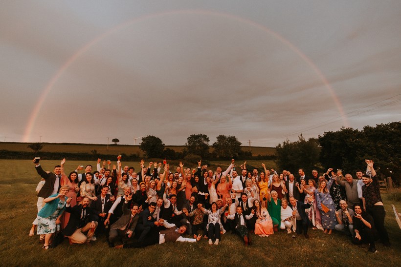 Wedding guests under a rainbow at Ash Barton