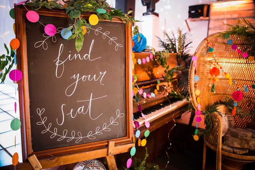 Chalk board at wedding with words find your seat''