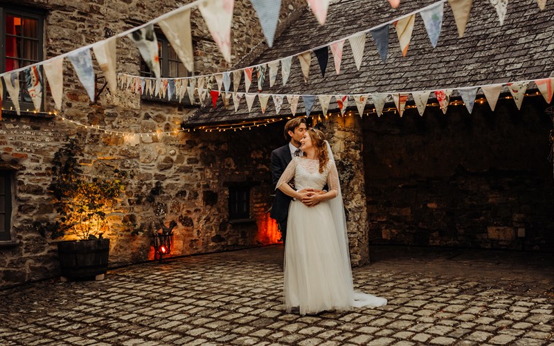 Ashbarton Estate - Bride and groom in courtyard with bunting Ash Barton Devon wedding venue