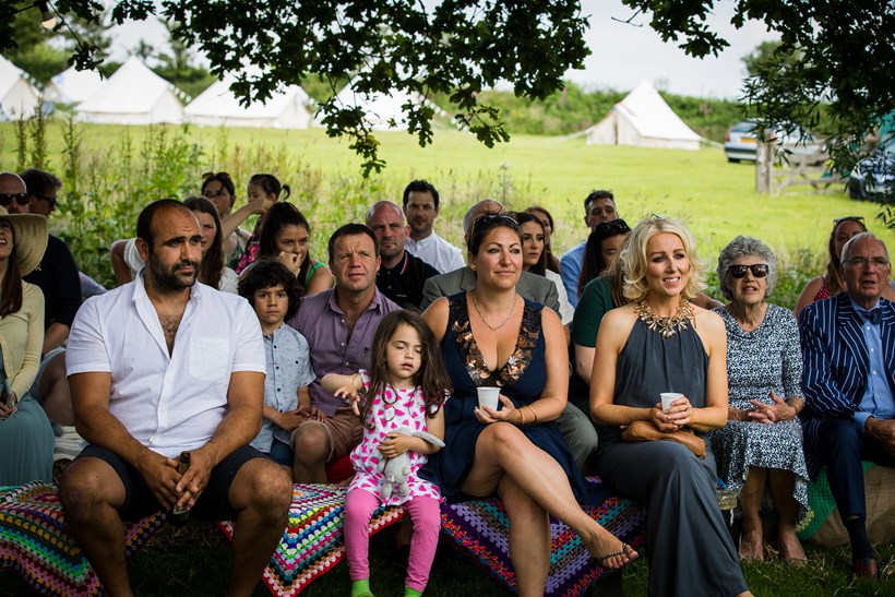 Wedding guests seated in front of tents at Ash Barton Devon wedding venue