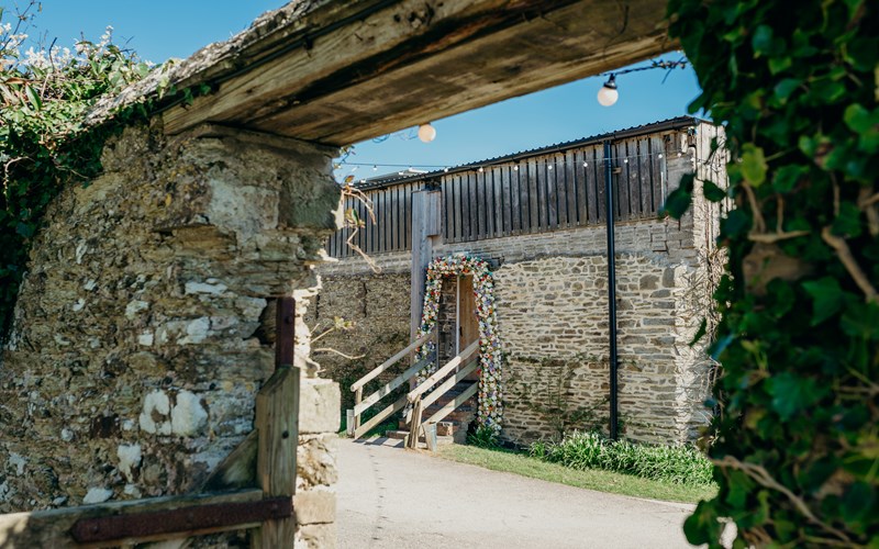 Ashbarton Estate - View of chapel door through arch at Ash Barton wedding venue Devon 