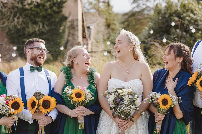 Bride with bridesmaids and bridesman holding sunflowers
