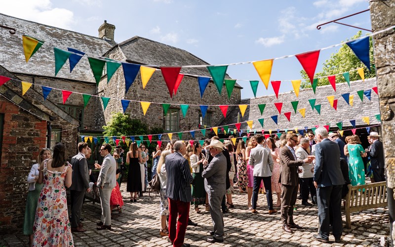 Ashbarton Estate - Wedding guests mingling in courtyard at Ash Barton wedding venue Devon